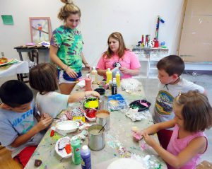 Jasmine Meurer (standing) helps youngsters with their arts projects.