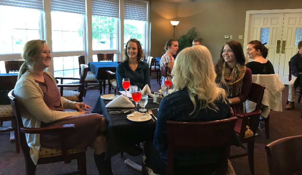 Students conversing during etiquette dinner