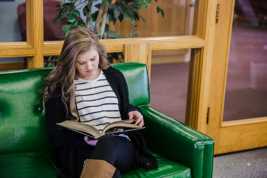 Haley Shepard reading a book in the library