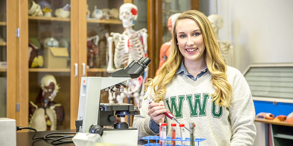 Ari Arnold posing with biology lab equipment