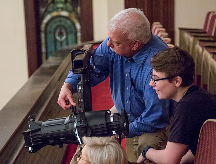 Joe Potter handling lighting equipment with students