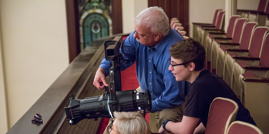 Joe Potter handling lighting equipment with students