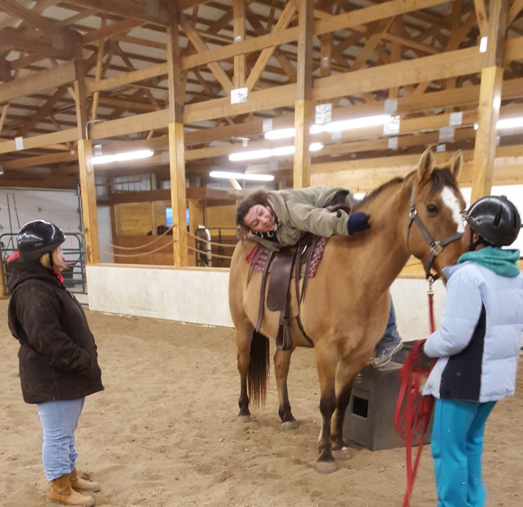 Rebecca Buchholz demonstrating leaning over a horse