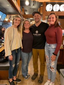 Four members of woods around the world crew posing in a restaurant 