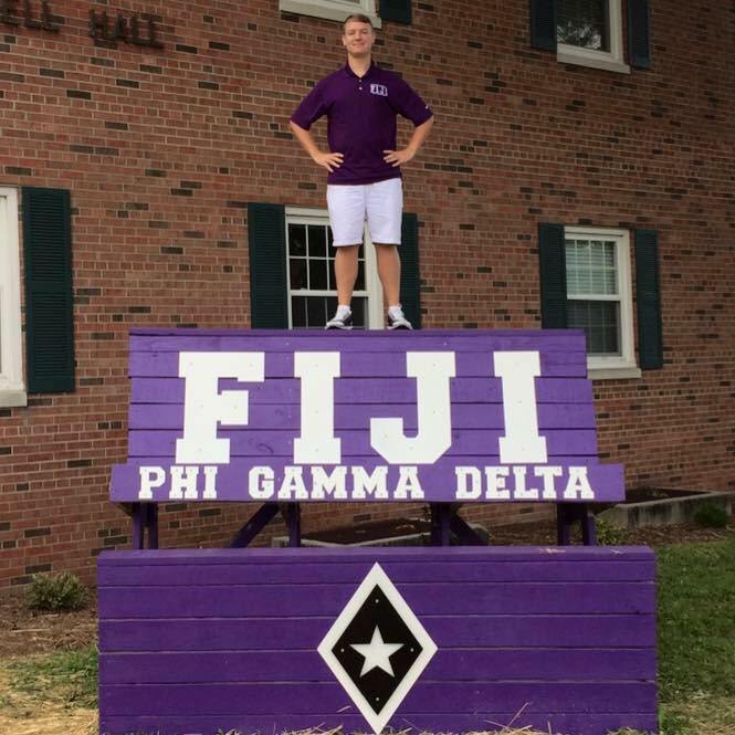 Stephen George posing on Phi Gamma Delta sign