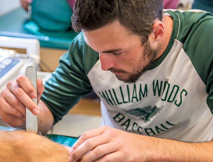 Student wrapping a knee