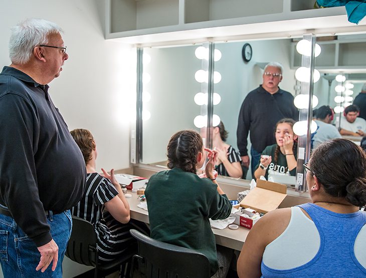 Students working on stage makeup with Professor Joe Potter