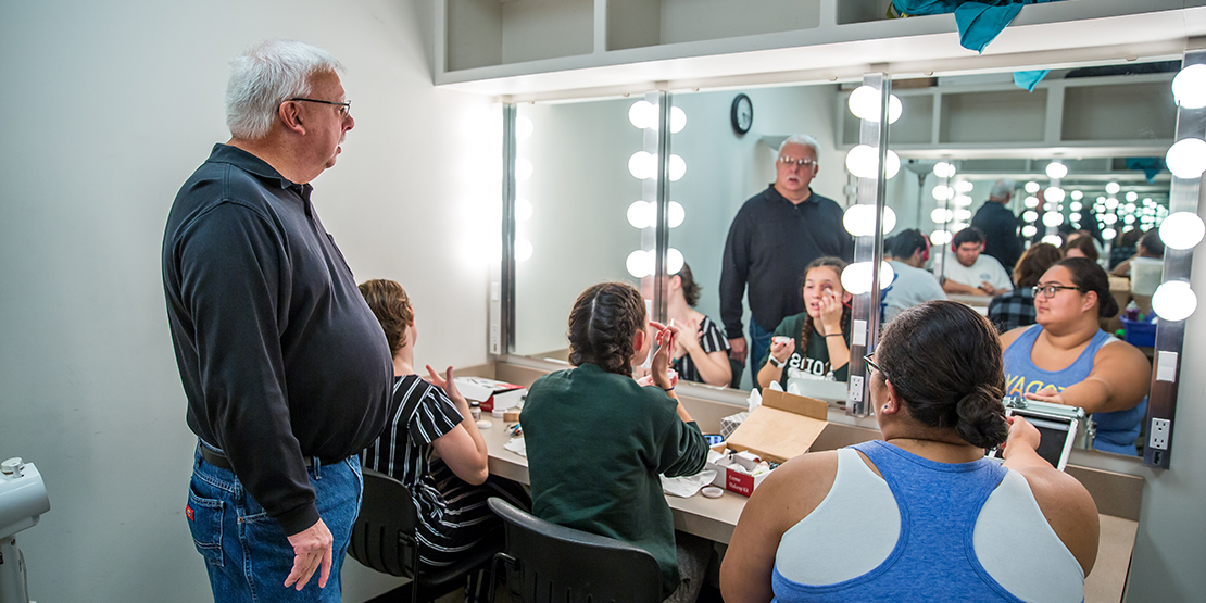 Students working on stage makeup with Professor Joe Potter