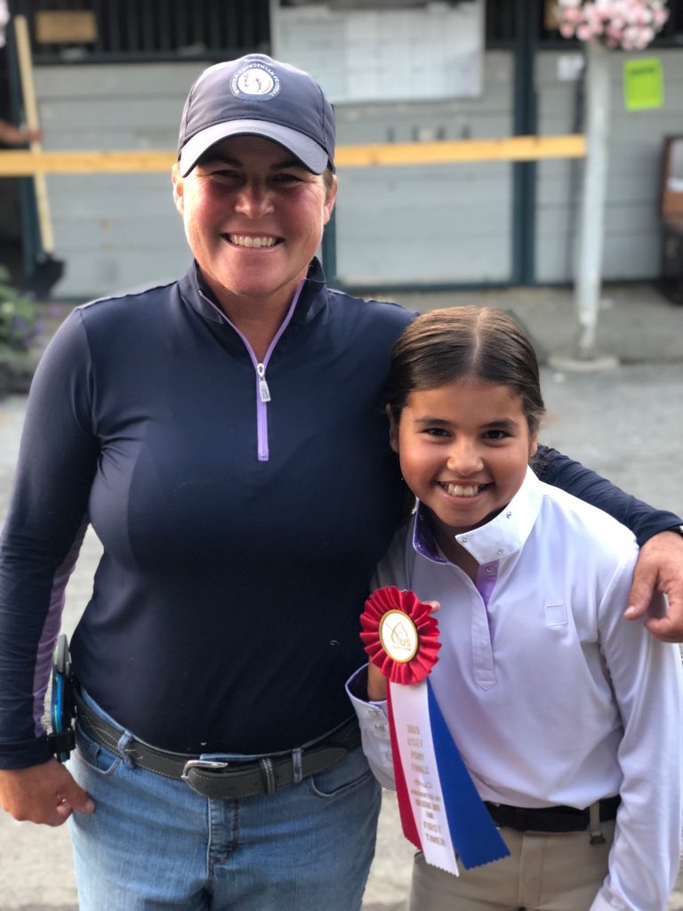 Picture of Patti with a student and a ribbon