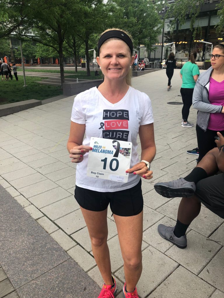 Photo of Kristina Baum holding her marathon number