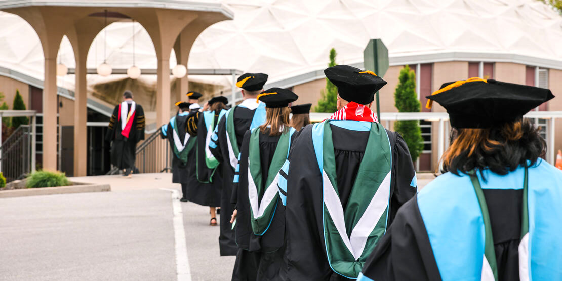 William Woods University faculty walk in line towards the stage for commencement