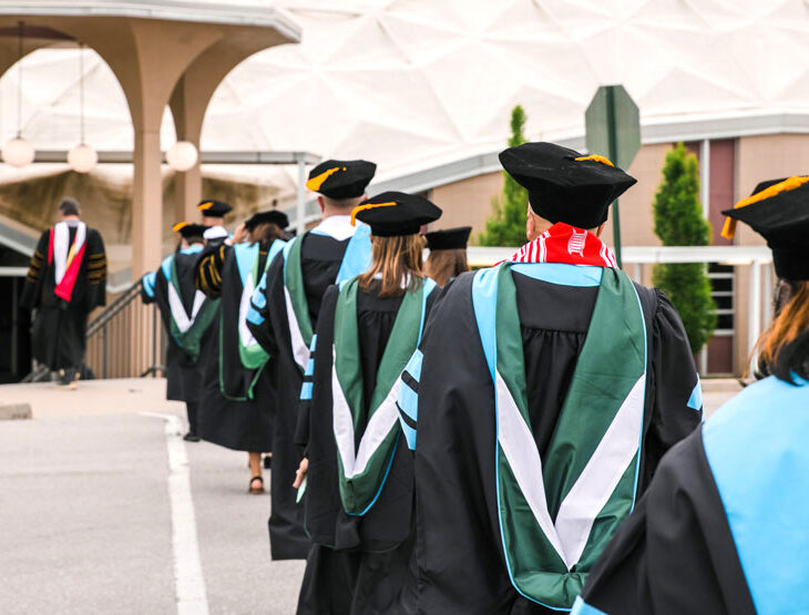 William Woods University faculty walk in line towards the stage for commencement