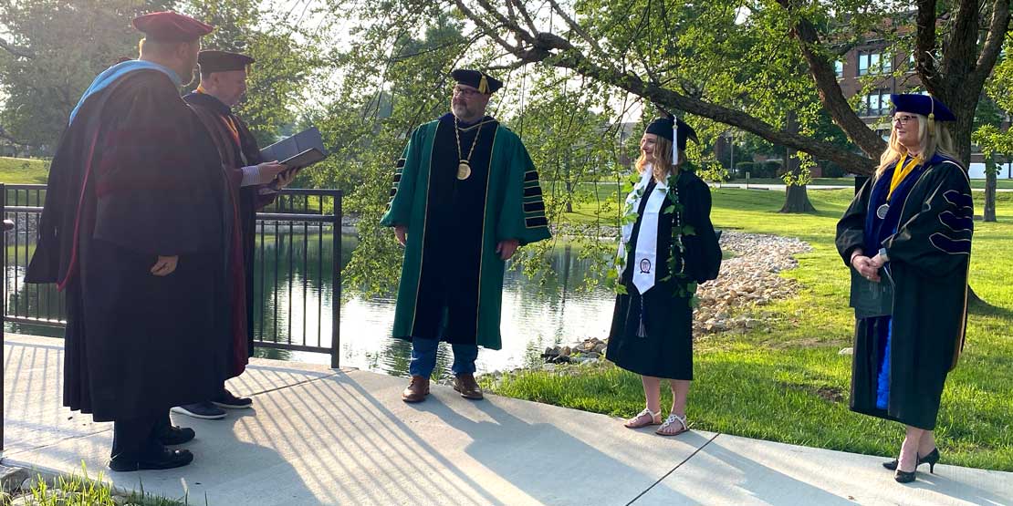 Graduate Sara Schaefer and the WWU administration on the senior bridge