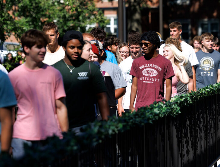 students walk across the senior lake bridge during the Ivy Ceremony