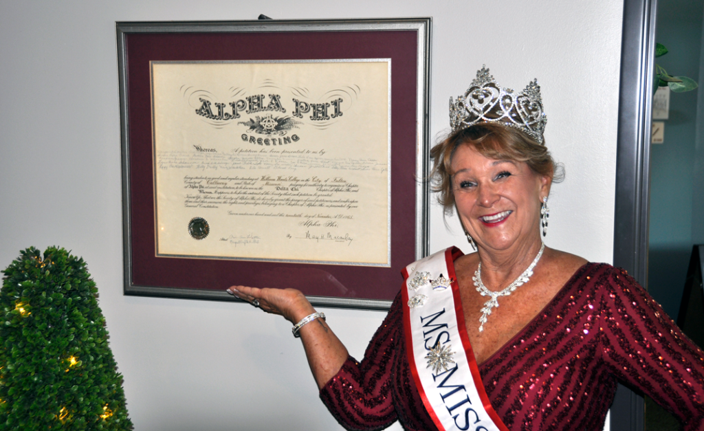 Christy posing in front of an Alpha Phi certificate on WWU campus